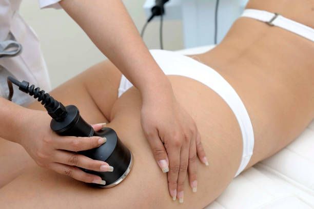 Man receiving back massage at a spa. A therapist's hands on his back, candles lit in the background.