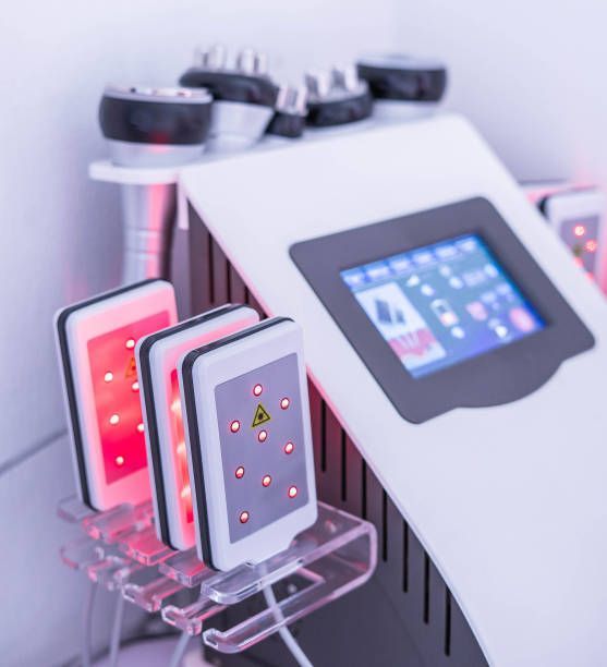 Woman receiving a facial treatment with a device, lines overlaid on face. Indoors.