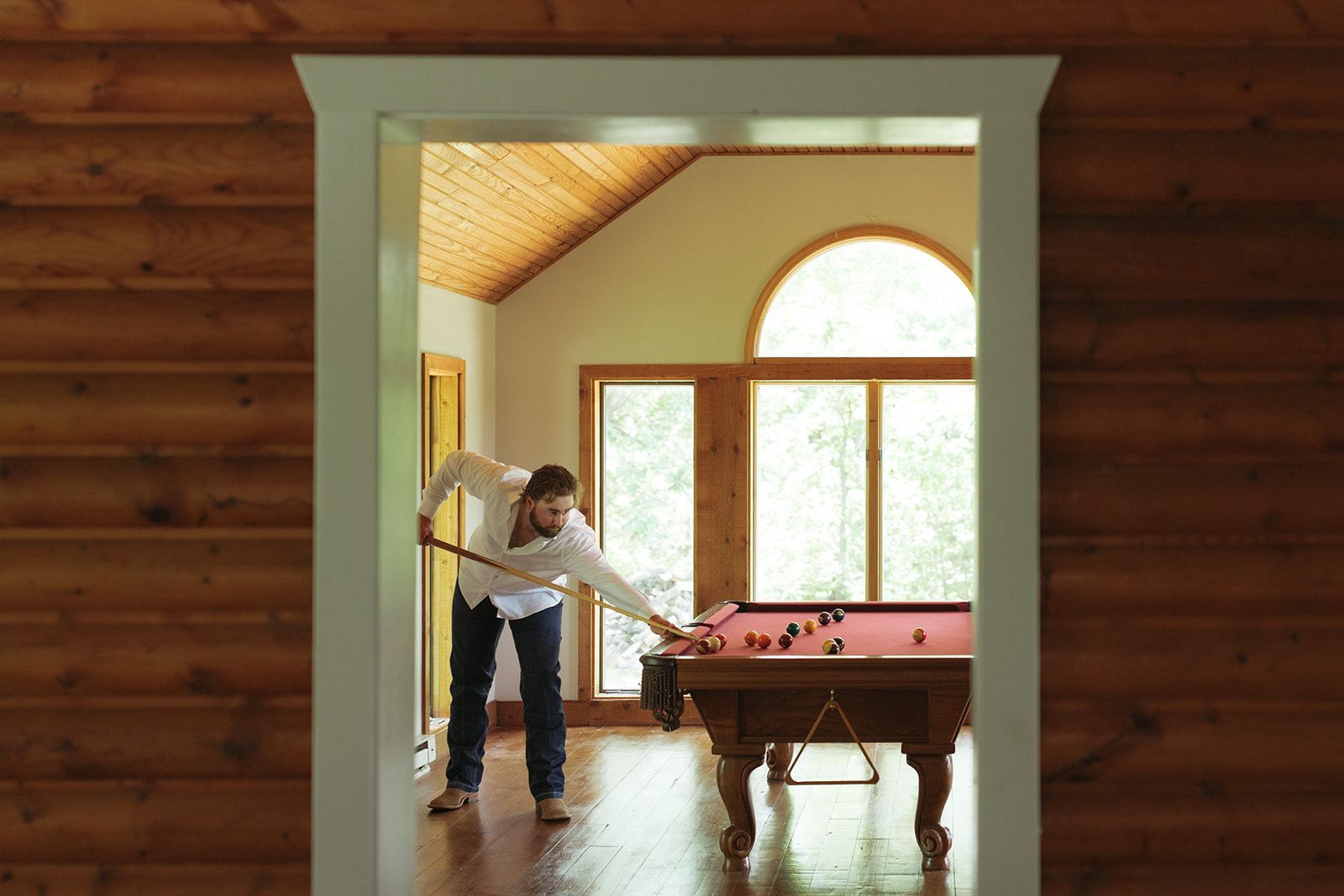 Groom at the Champagne Barn Cabin Plays Billiards While Preparing for His Mid-Missouri Wedding.