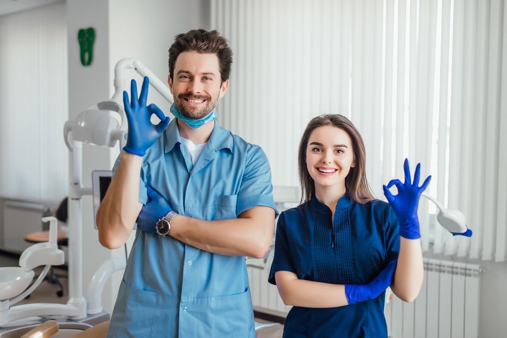 A man and a woman are standing next to each other in a dental office.