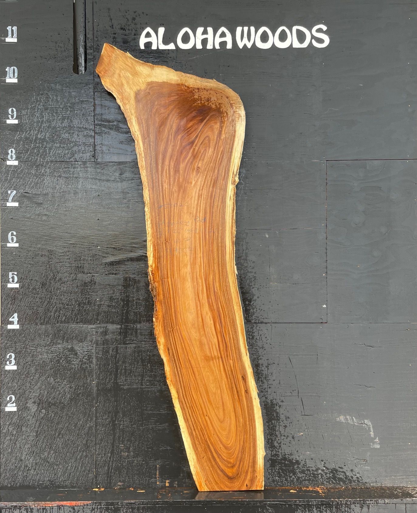 A piece of wood with the words aloha woods above it