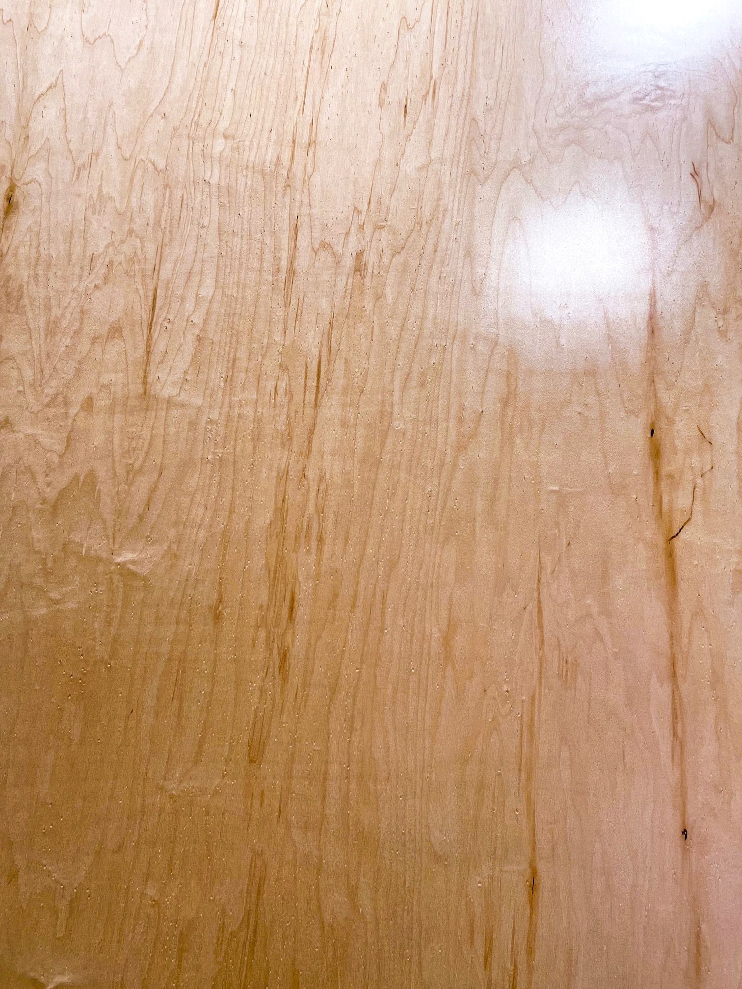 A close up of a piece of wood with a shiny finish.