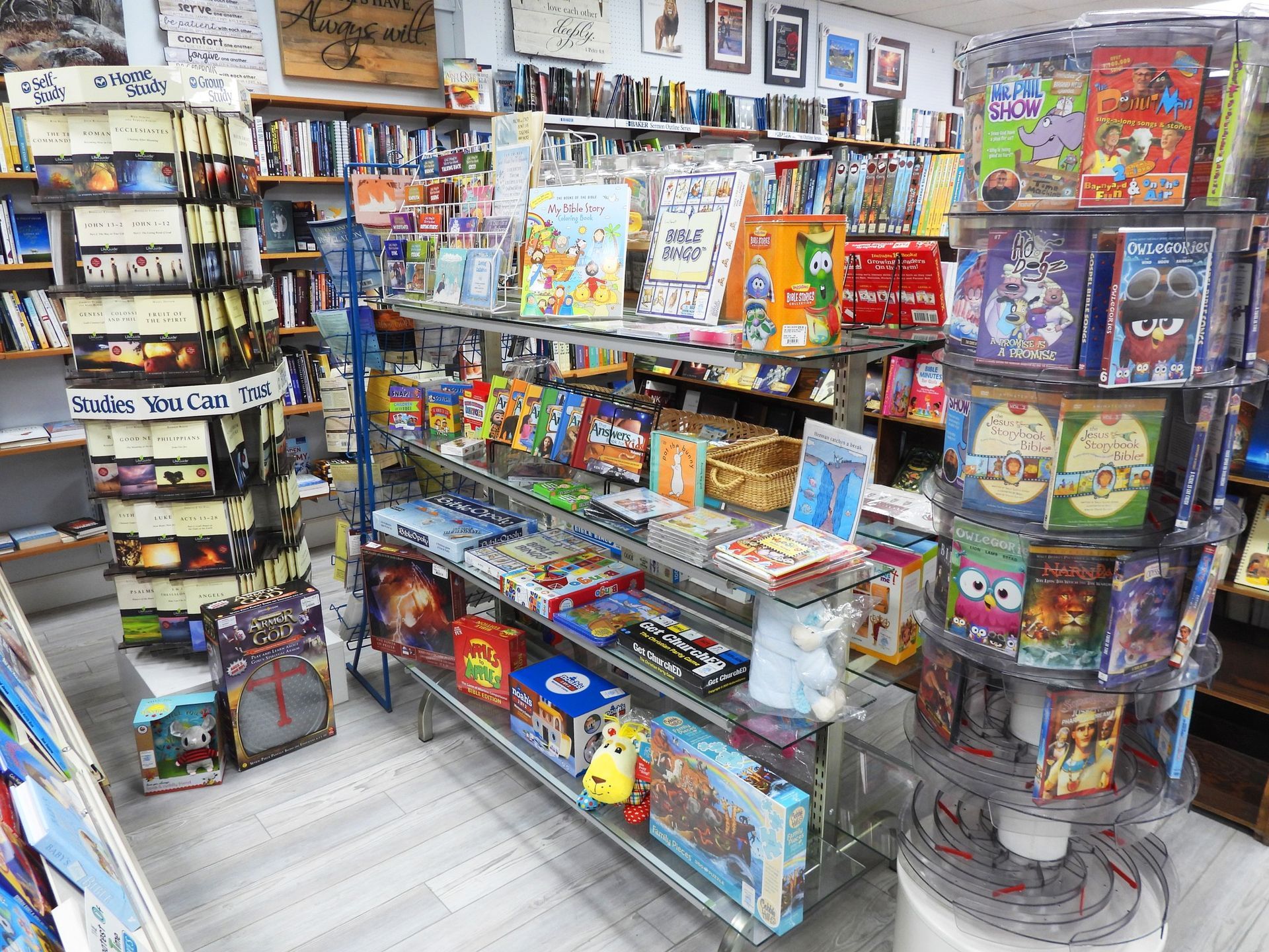 Inside a brightly lit bookstore, shelves are filled with books and games.