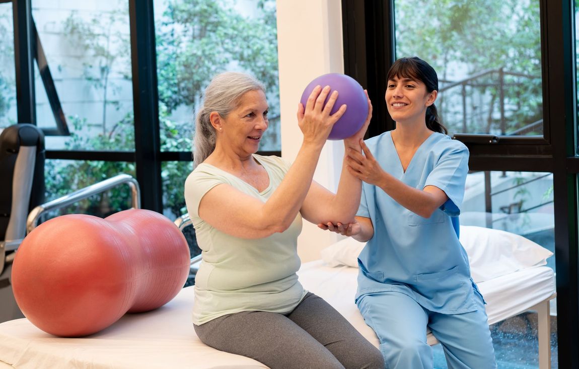 Elderly Woman Holding a Purple Ball While a Nurse Helps Her — Marlton, NJ — Luna Lymphatic Care