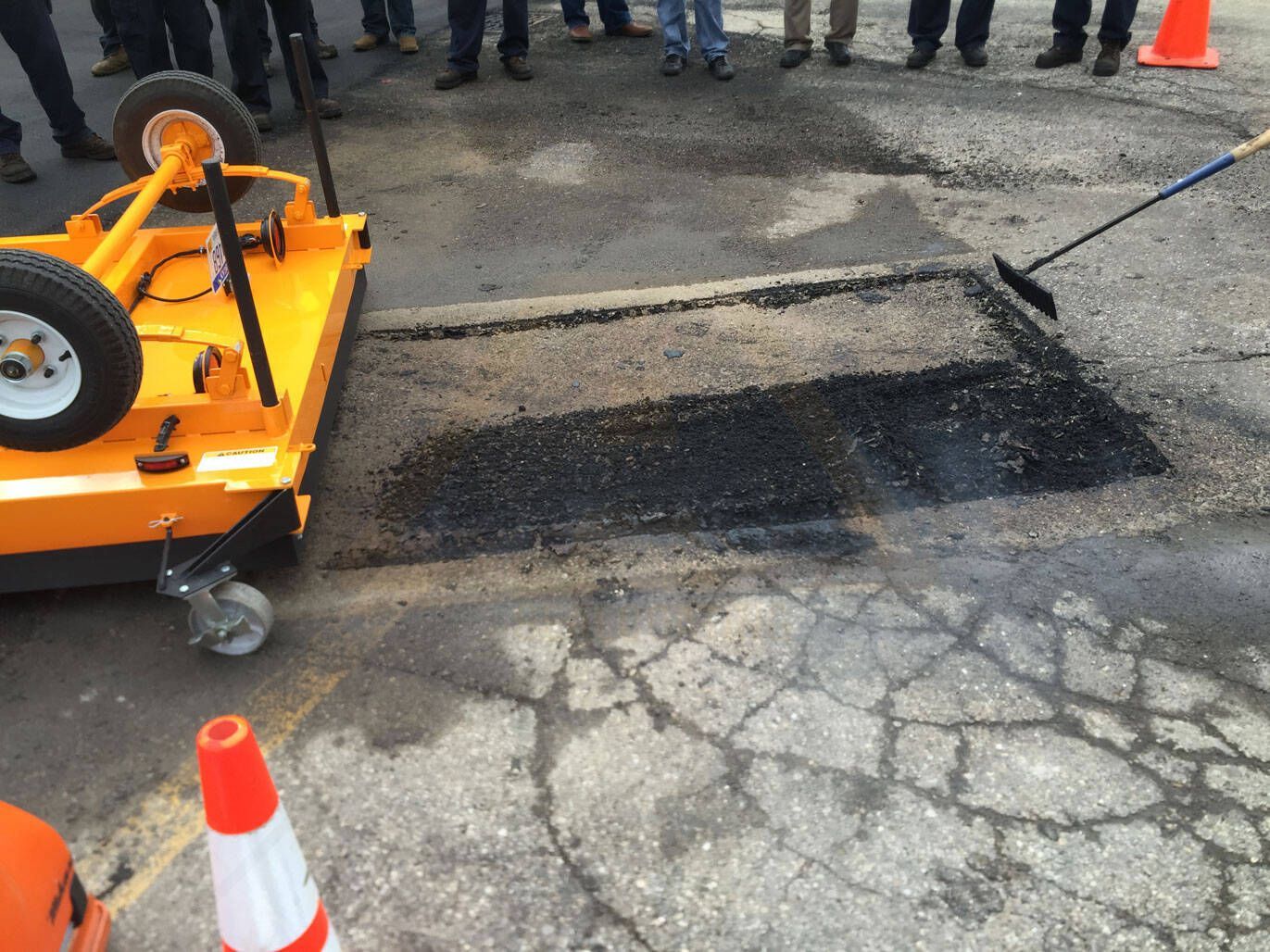 An empty street in a residential area with a lot of trees and buildings.