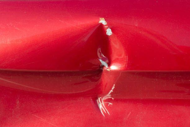 A close up of a red car with a hole in it.