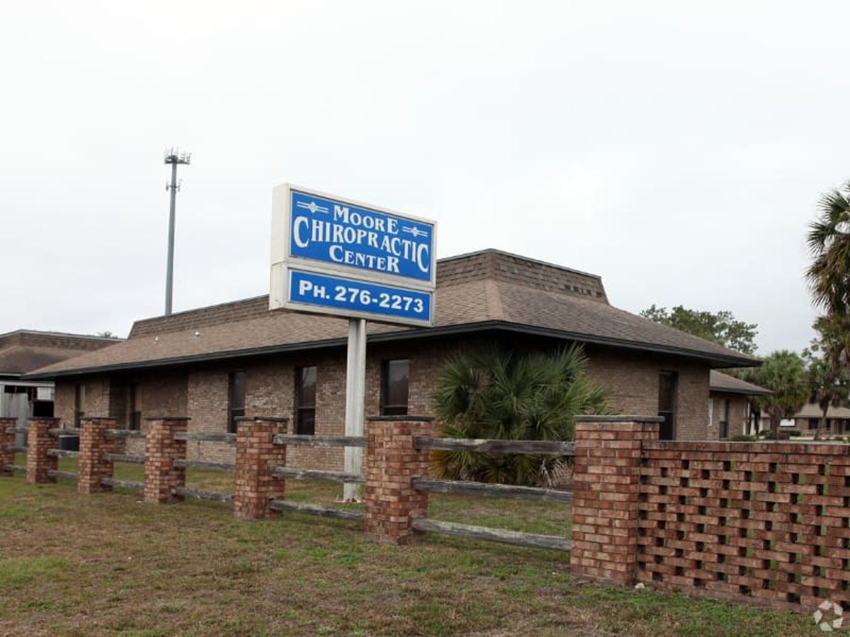 Brick building with sign: Mount Dora Chiropractic Center. Ph. 276-2273. Fence and grass in front.
