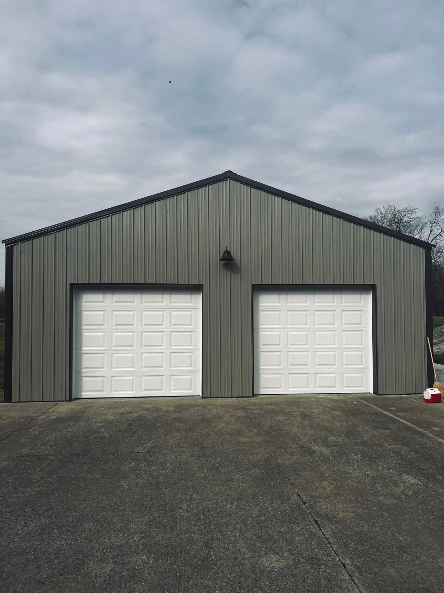 A large metal garage with two white garage doors.