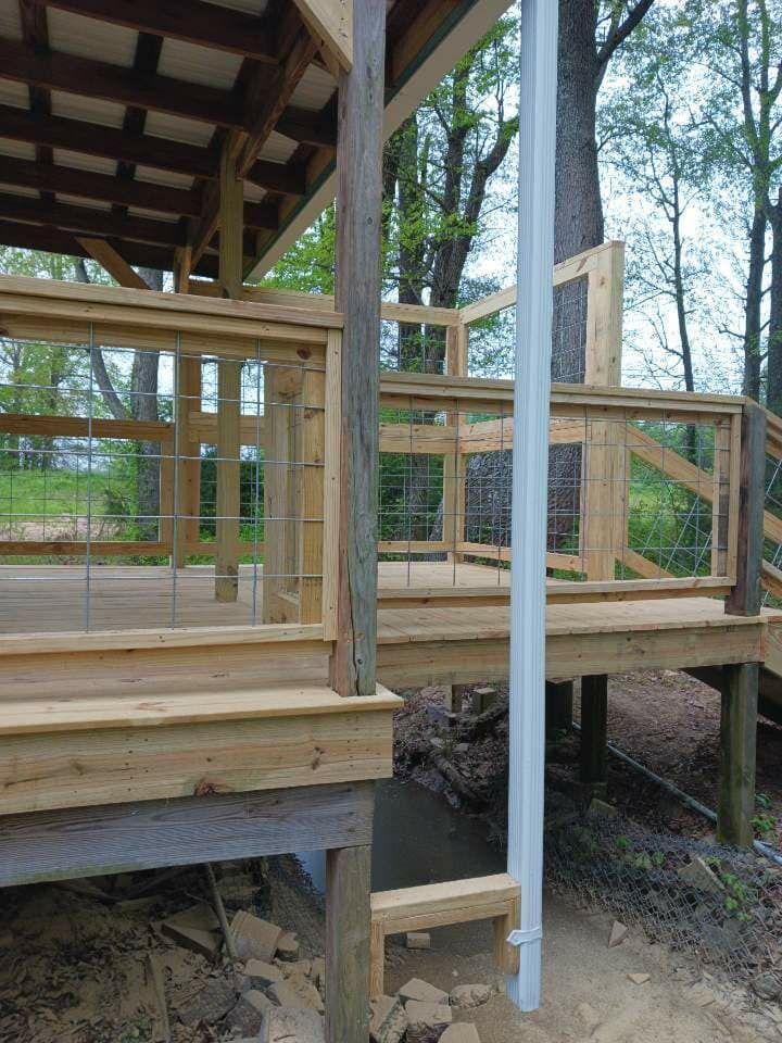 A wooden deck with a metal railing and stairs