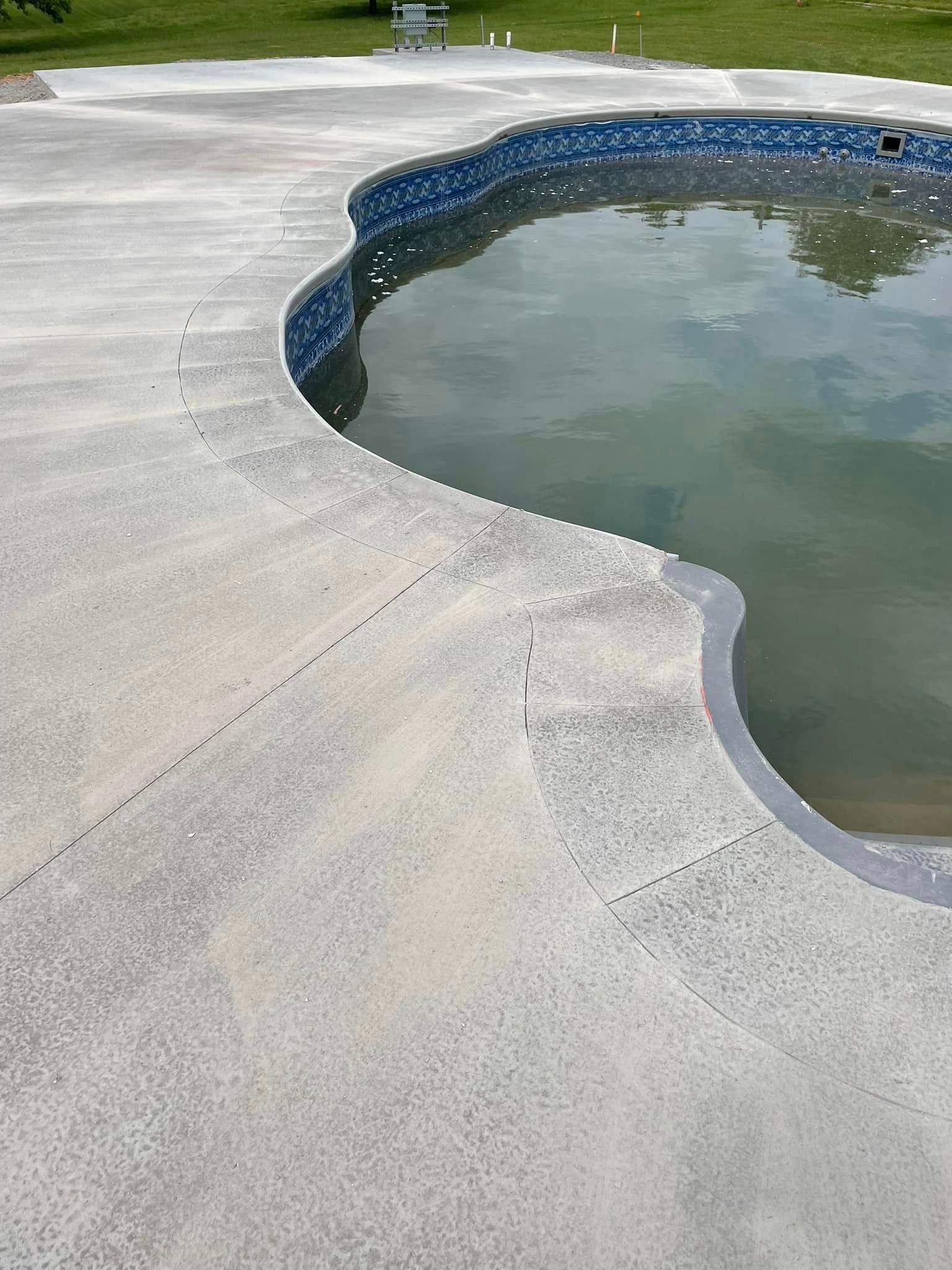 A swimming pool with a concrete deck and a blue tile border.