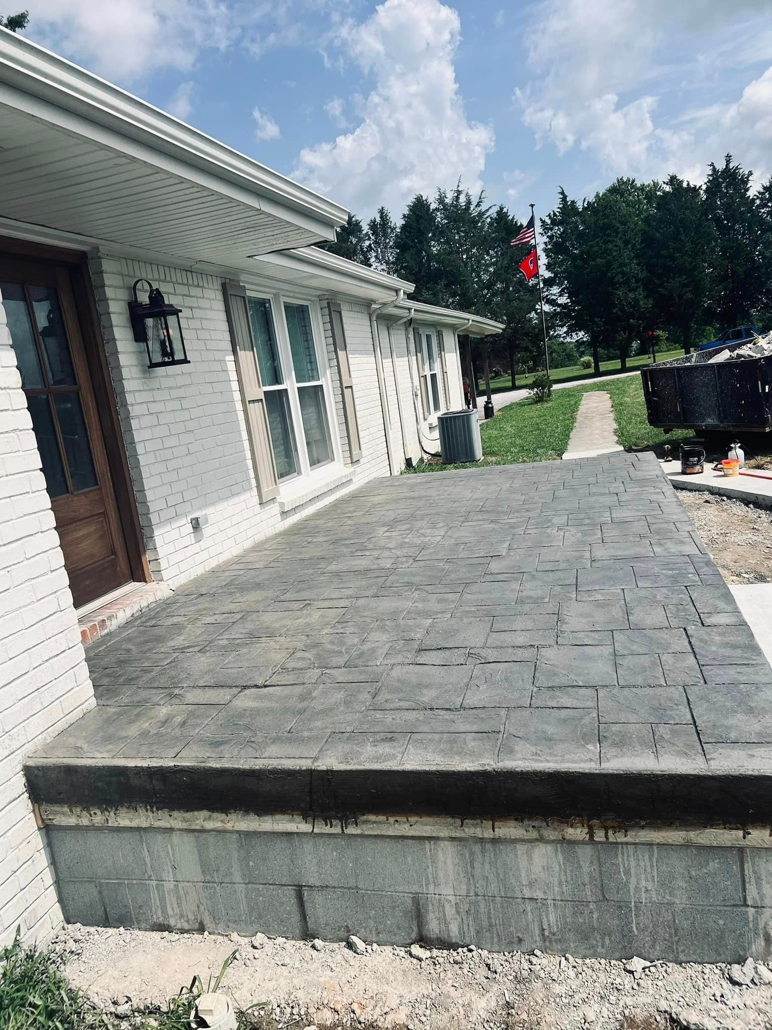 A brick walkway is being built in front of a house.