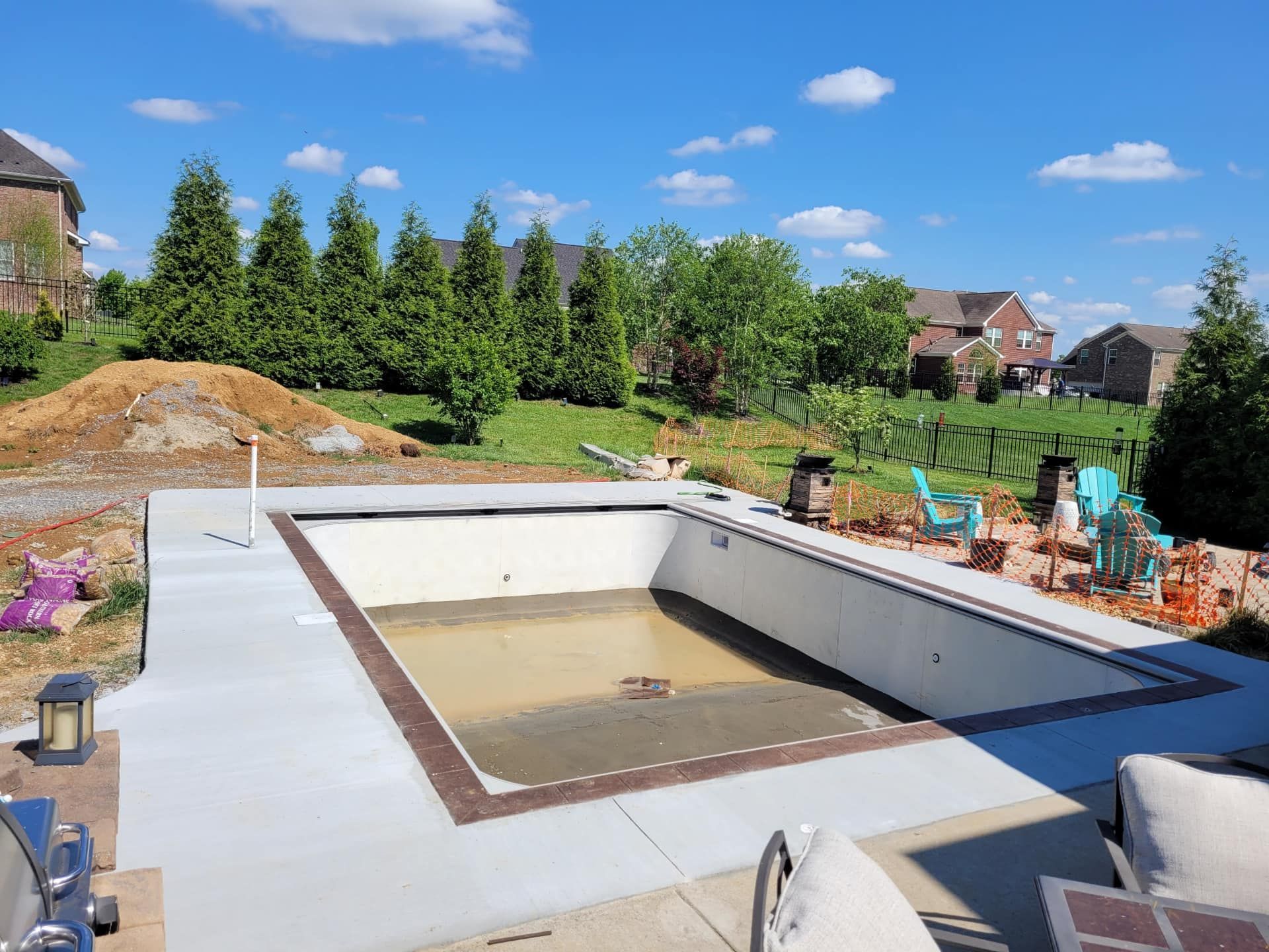A large swimming pool is being built in a backyard.