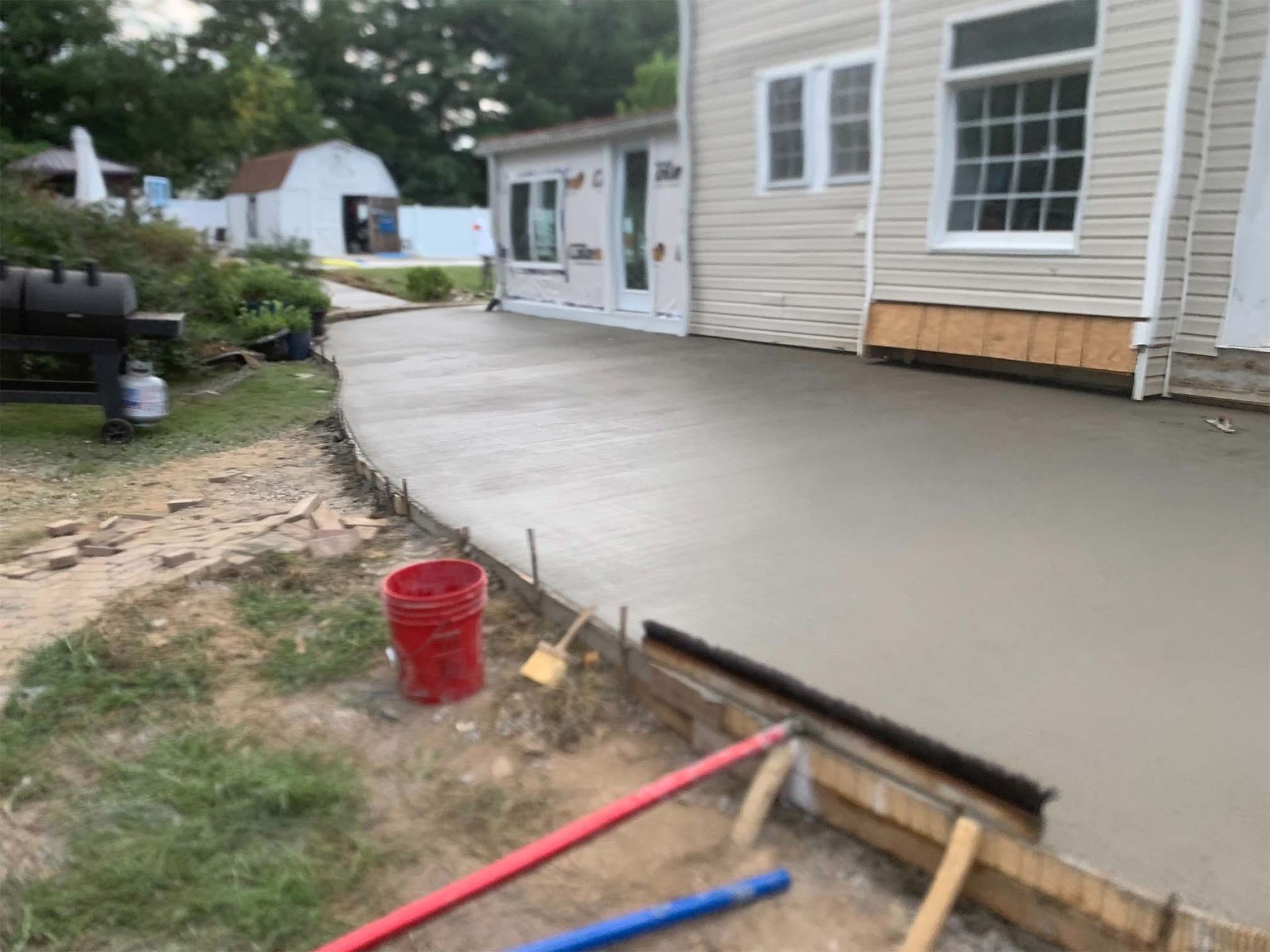A concrete walkway is being built in front of a house.