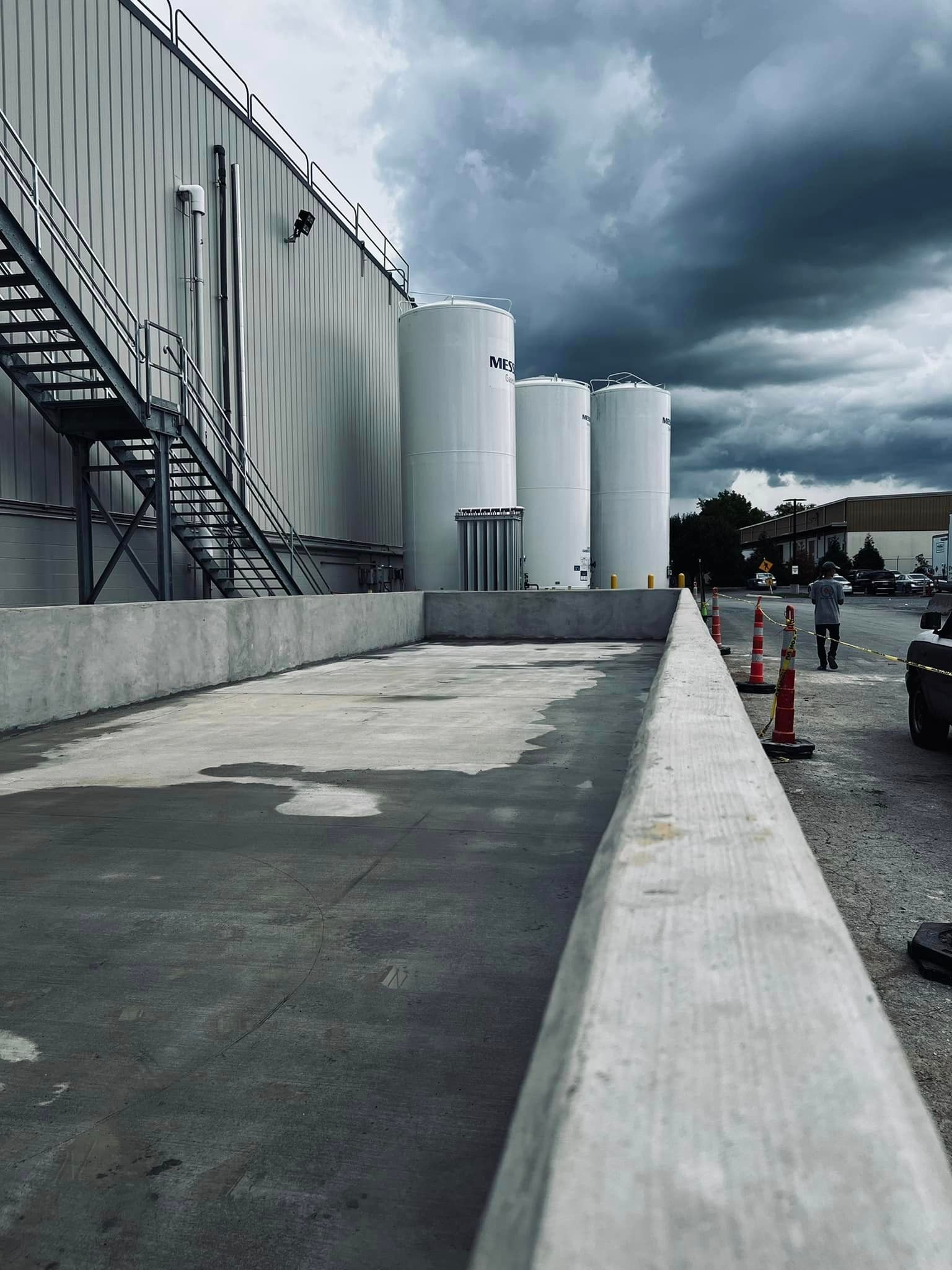 A row of white tanks are lined up in front of a building.