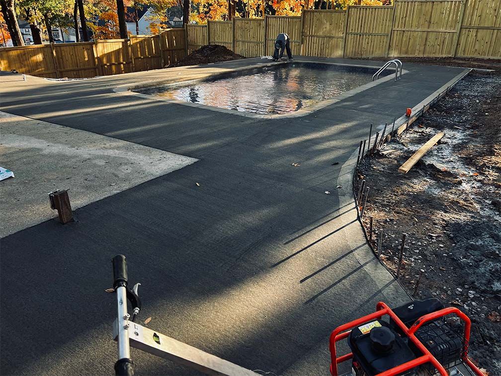 A man is working on a swimming pool in a backyard.
