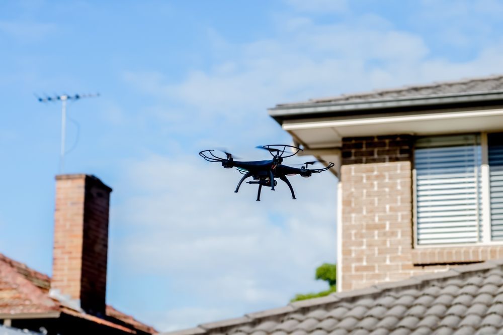 Drone Hovering Near a Brick House Roof — NQ Video Surveillance in Bungalow, QLD