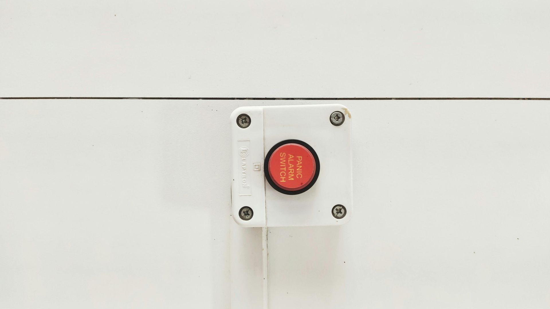 Red Emergency Stop Button on White Panel — NQ Video Surveillance in Bungalow, QLD