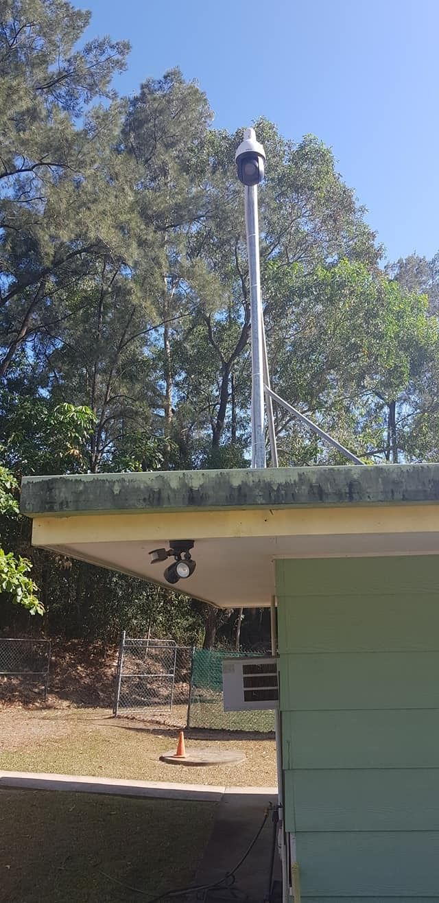 A Tall Metal Pole With a Siren on Top Mounted on a Green Building — NQ Video Surveillance in Mackay, QLD