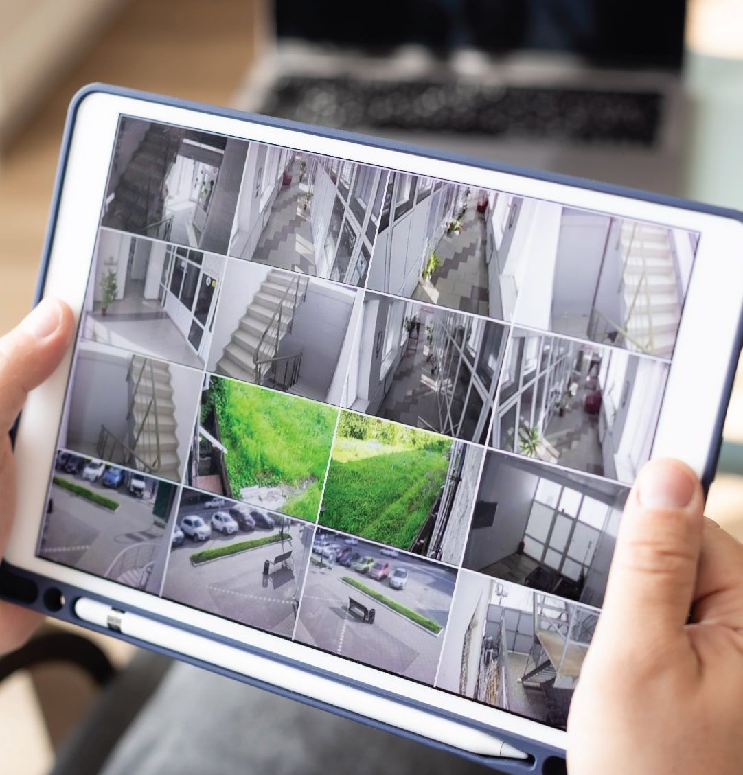 Person Holding a Tablet Displaying a Grid of Security Camera Feeds — NQ Video Surveillance in Bungalow, QLD