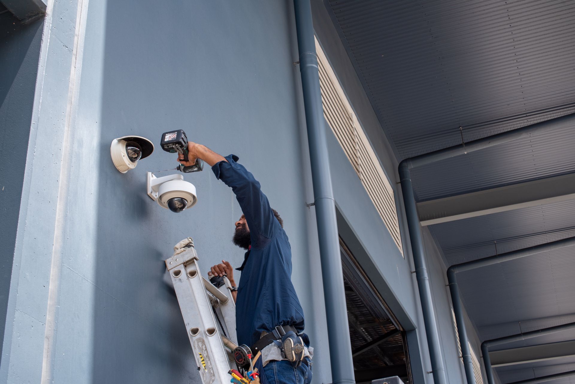Security Camera With Smartphone Displaying a Home Interior — NQ Video Surveillance in Bungalow, QLD