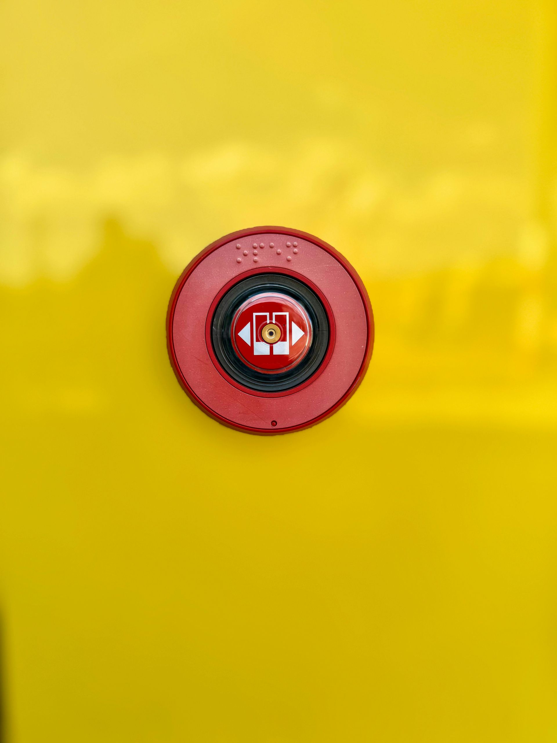 Red Emergency Button on a Yellow Surface — NQ Video Surveillance in Airlie Beach, QLD