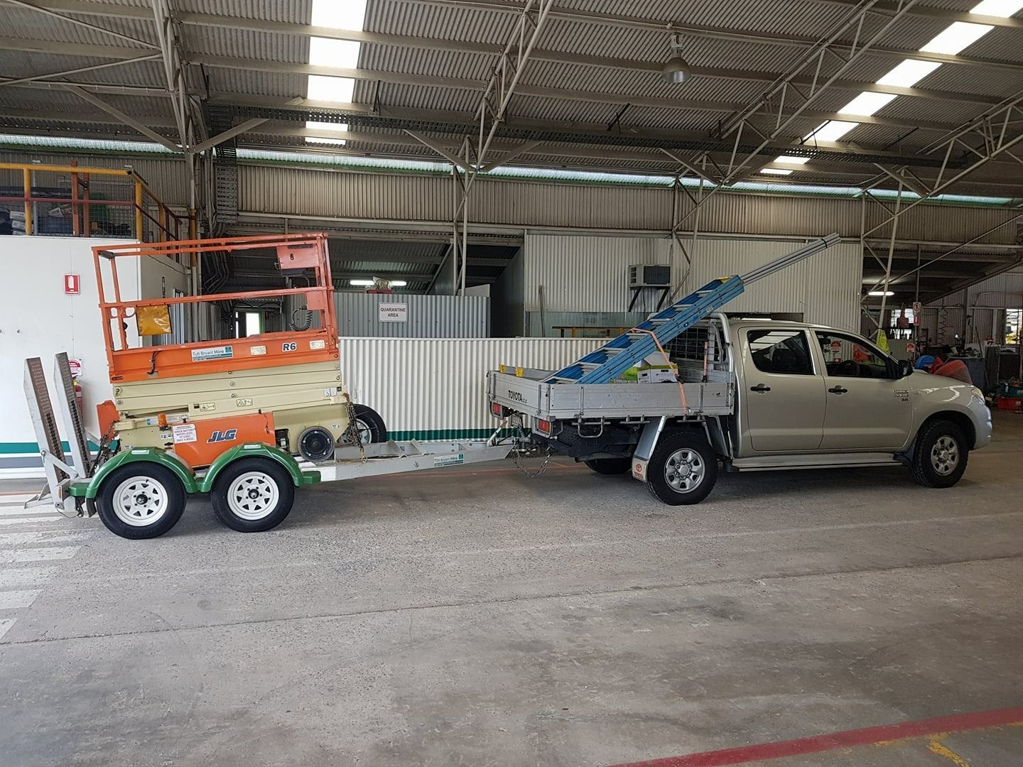 A Silver Pickup Truck Towing an Orange and Green Scissor Lift Trailer — NQ Video Surveillance in Bungalow, QLD