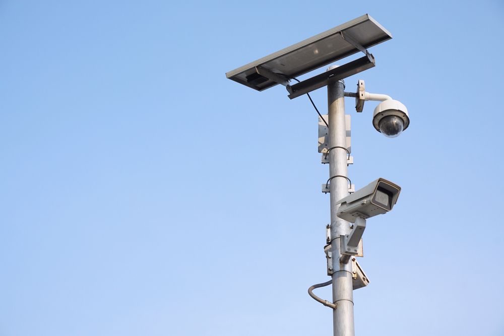 Security Cameras and Solar Panel Mounted on a Tall Pole Against a Blue Sky — NQ Video Surveillance in Bungalow, QLD