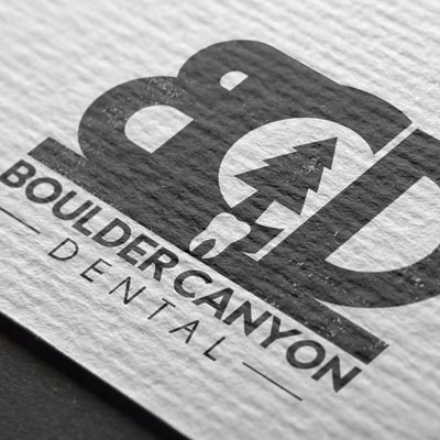 A black and white logo for boulder canyon dental is on a piece of paper.