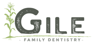 A logo for gile family dentistry with a tree in the background