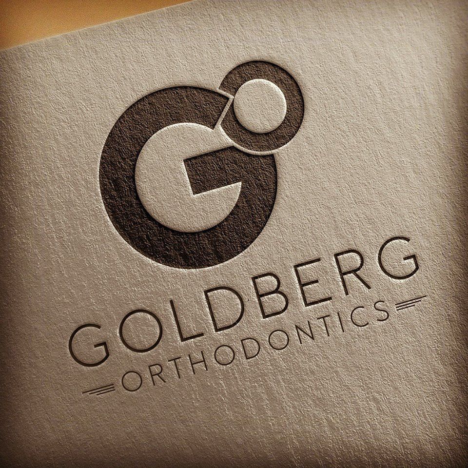 The logo for goldberg orthodontics is on a piece of paper