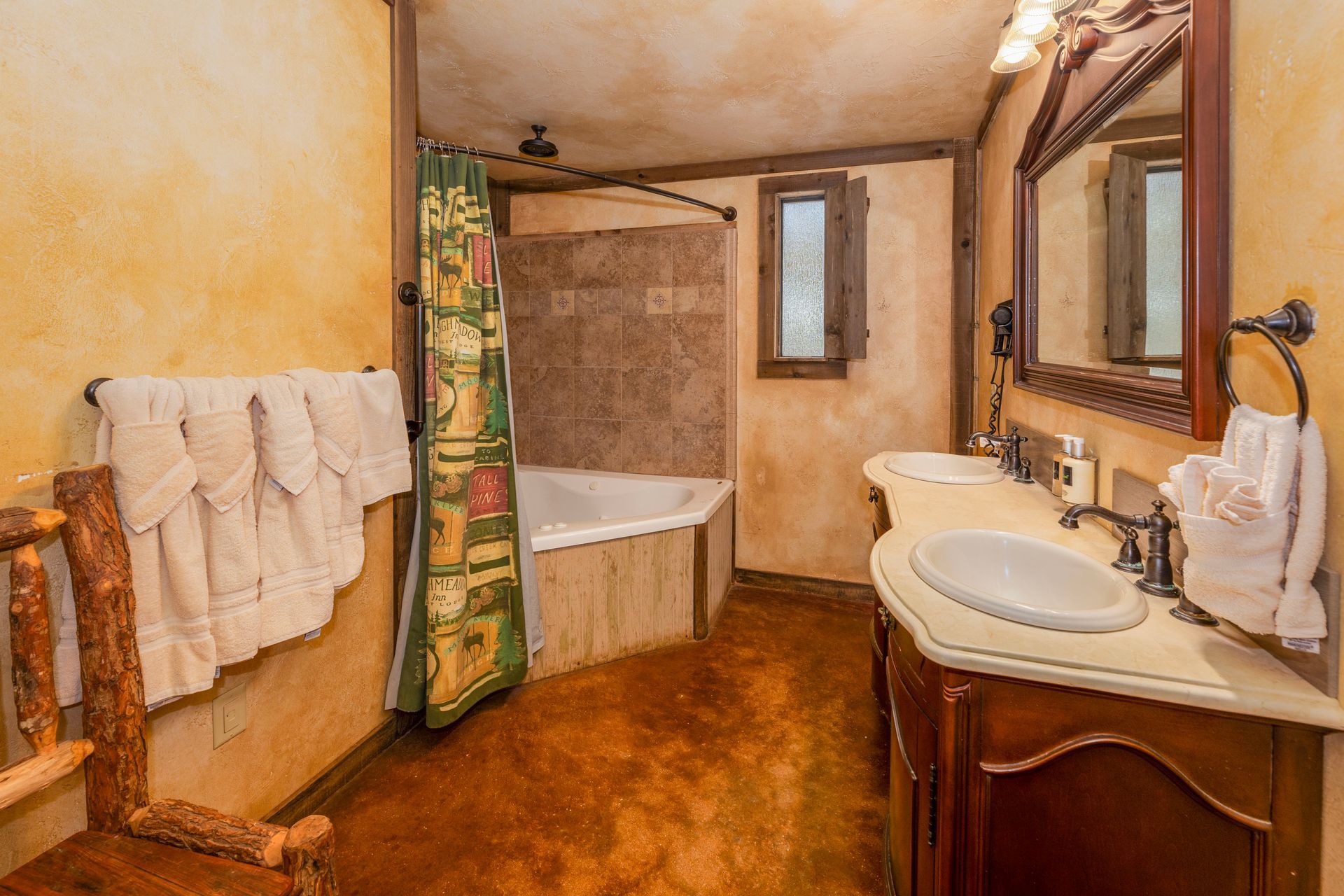 Bathroom with rustic decor; brown walls, vanity, and tub surround; white towels and tan floor.