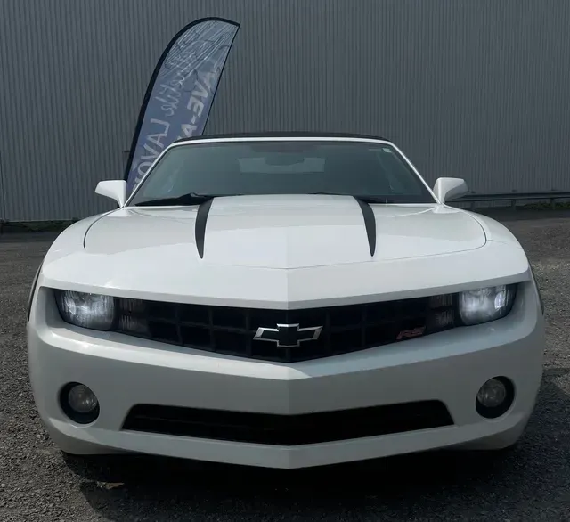 Chevrolet Camaro RS blanche garée à l'extérieur.