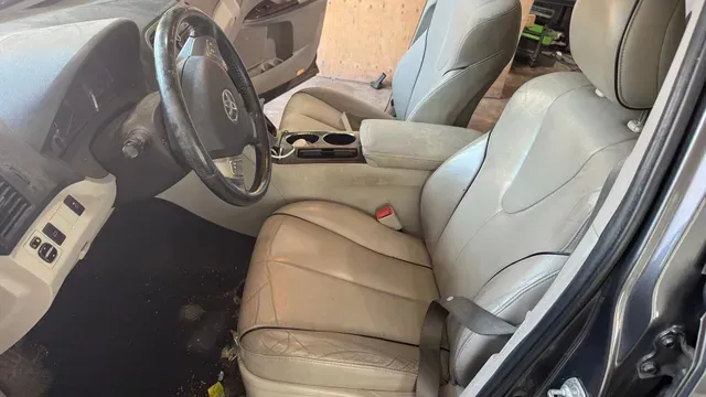 Intérieur beige d'une voiture, montrant le siège conducteur, le tableau de bord et la console centrale.