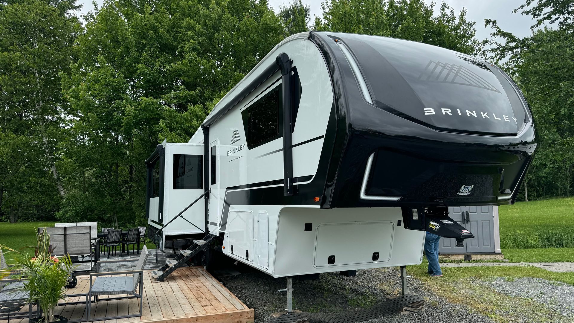 Remorque à sellette Brinkley blanche et noire garée à l'extérieur sur une plate-forme en bois.