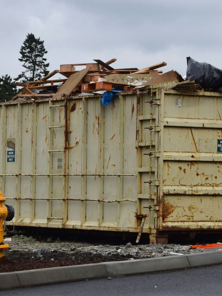 A large dumpster with a sign that says ' waste management ' on it