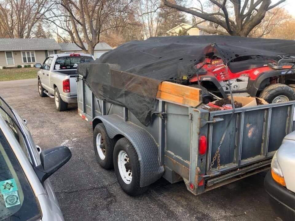 A truck is pulling a trailer with a four-wheeler in it.