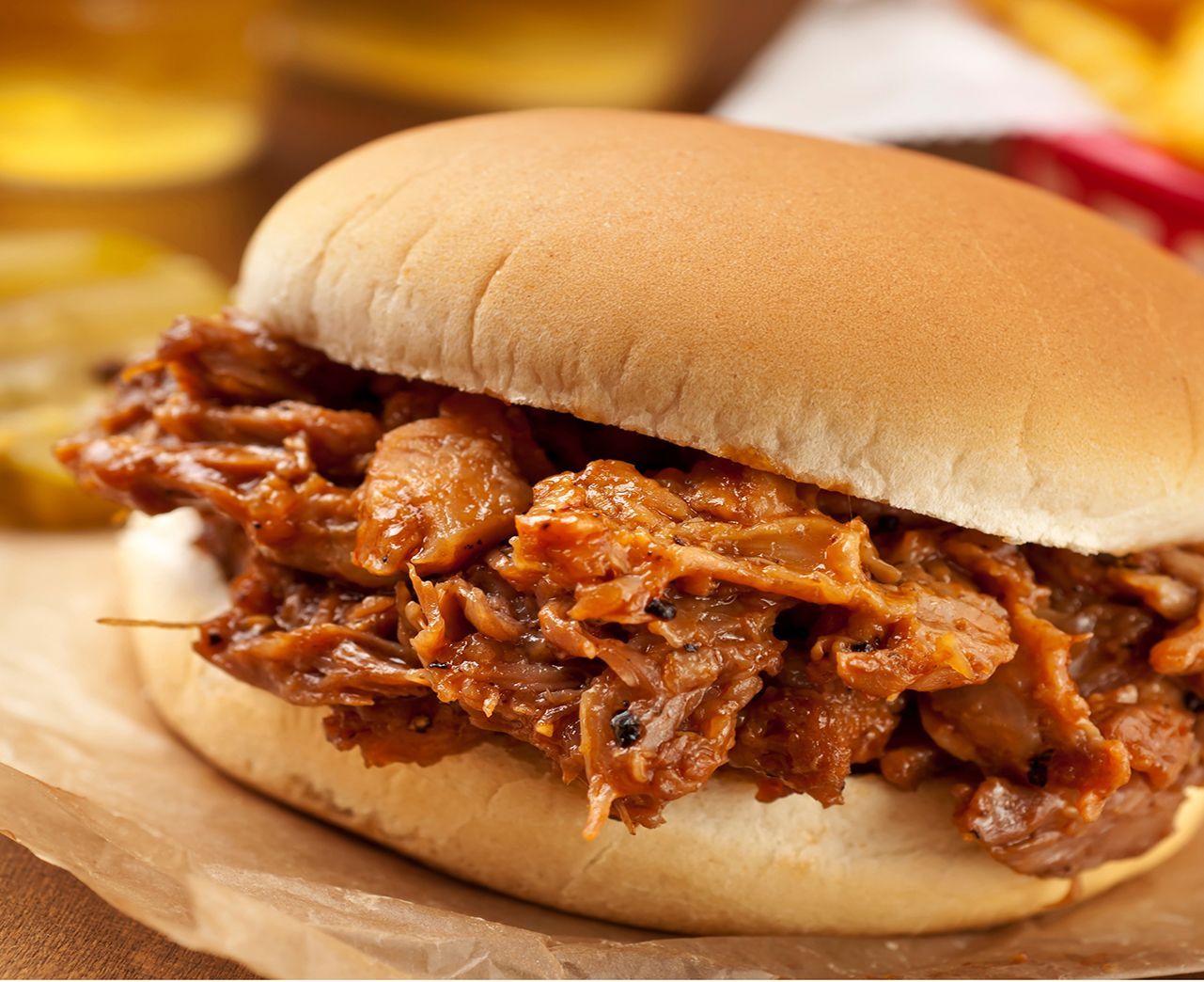 A double cheeseburger with lettuce tomato and pickles on a bun