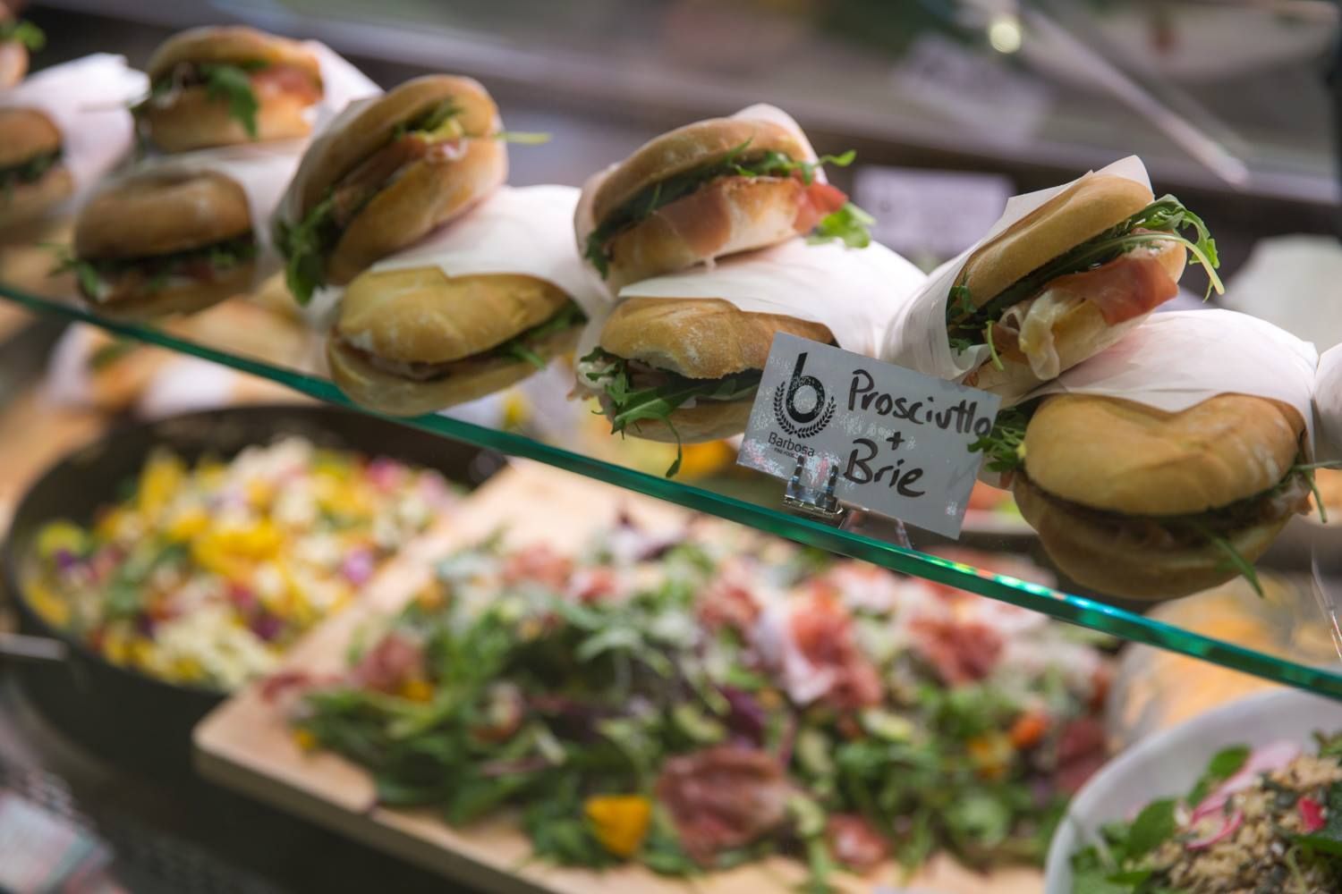 Prosciutto and Brie Sandwiches on Display Above Deli Salads — Barbosa Fine Food Deli in Robina, QLD