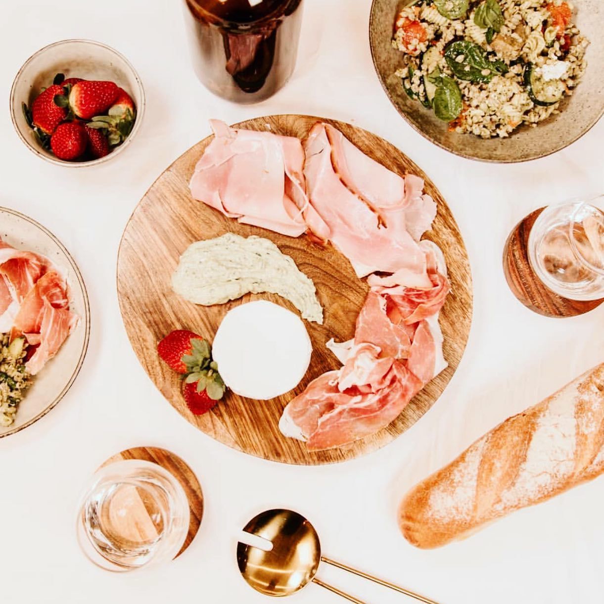 A Table Topped With Plates of Food and a Bottle of Beer — Barbosa Fine Food Deli in Robina, QLD
