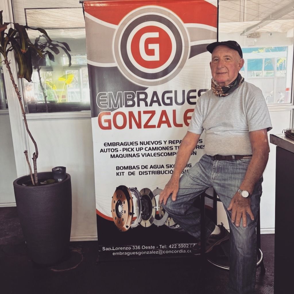 Hombre posando junto a una pancarta de