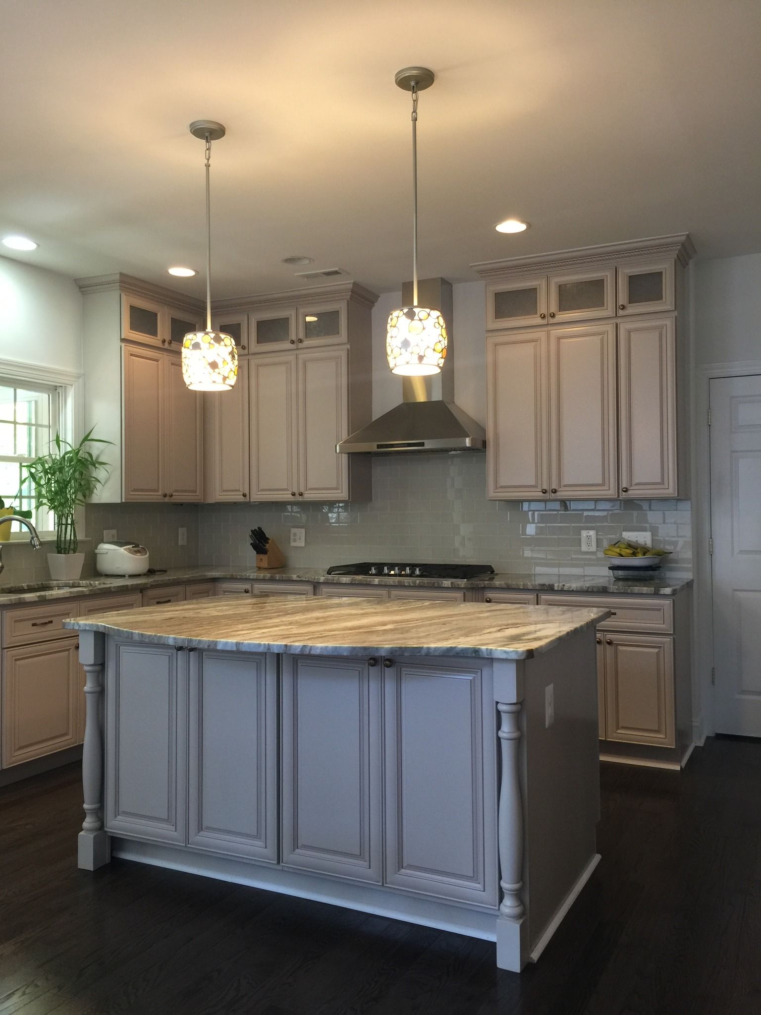 A modern kitchen with light gray cabinets, a large island, and two 
