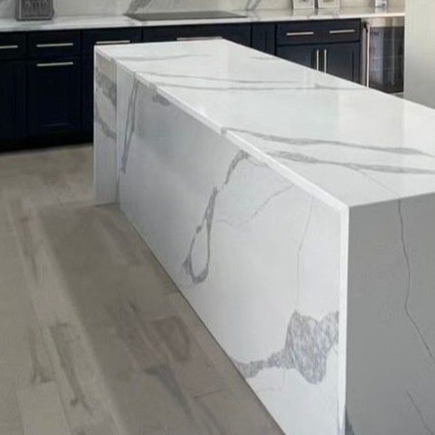 A modern kitchen island with a white quartz countertop featuring gray 