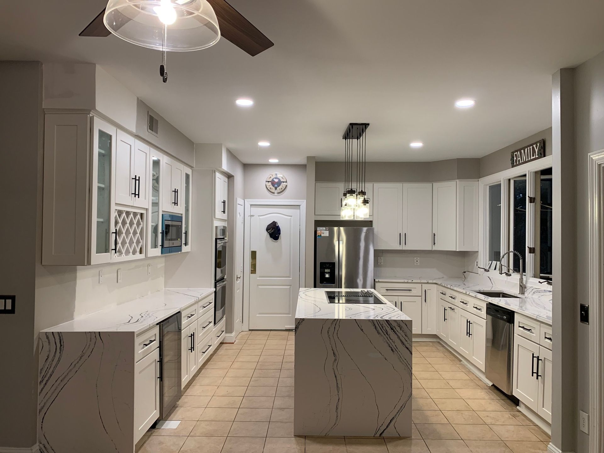 Kitchen showroom with cabinet displays. White and gray cabinets are featured, along with paint color samples on the wall.