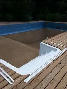 A swimming pool is sitting on top of a wooden deck.