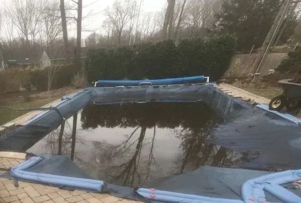 A swimming pool with a blue cover on top of it.