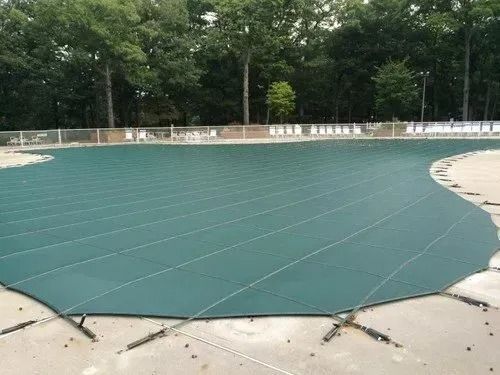 A swimming pool with a blue cover on it