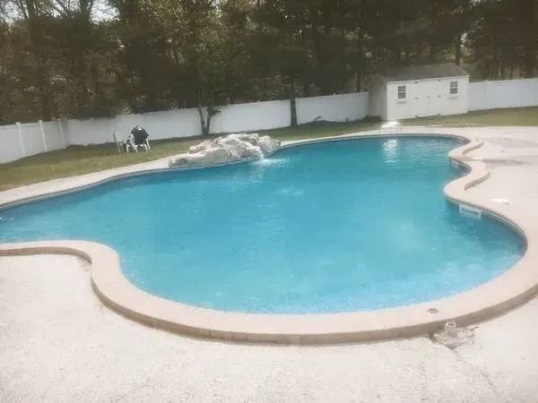 A large swimming pool with a waterfall in the middle of it.