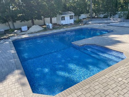 A swimming pool with a view of the ocean and palm trees