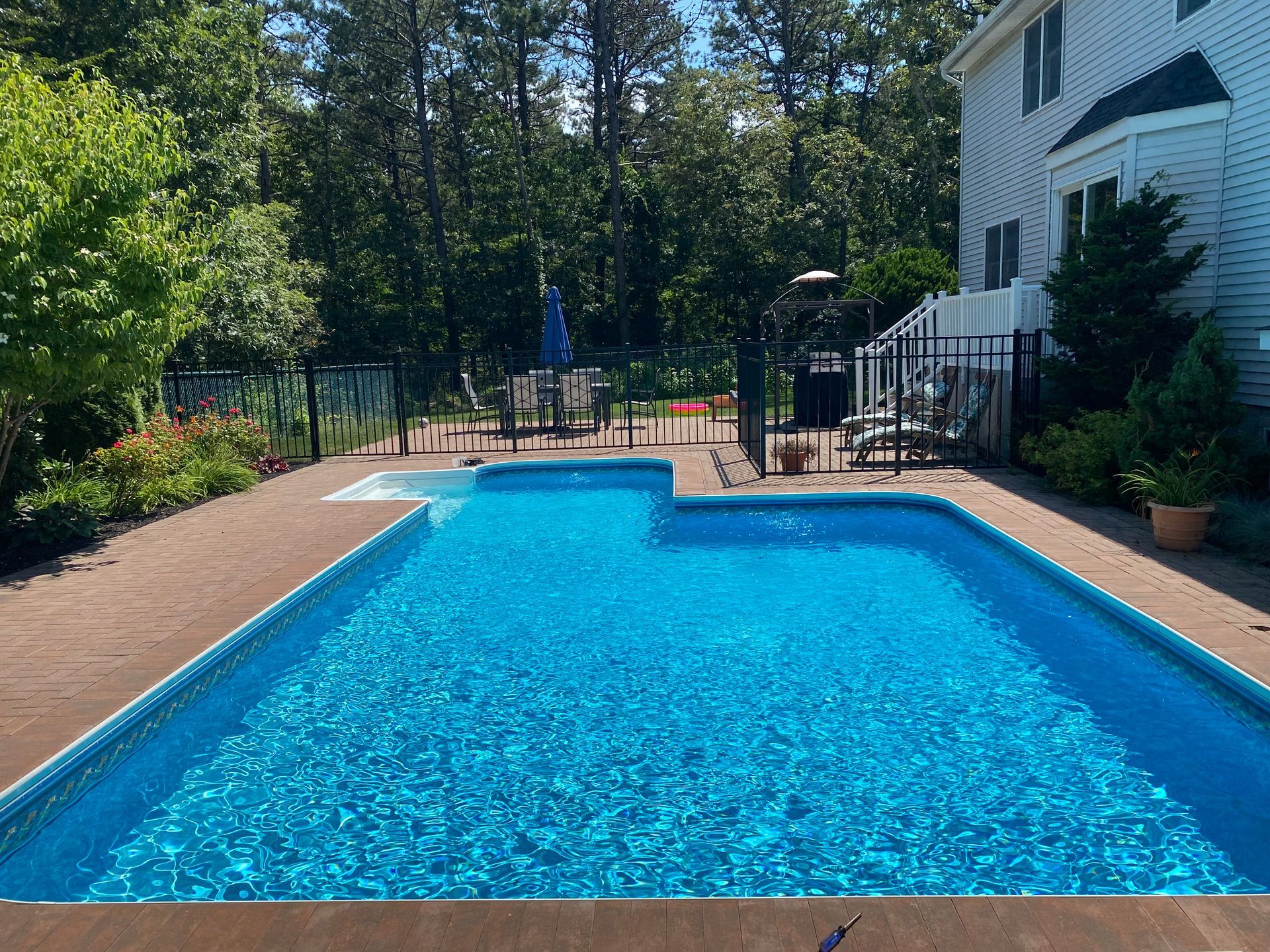 A swimming pool with blue tiles and white steps.