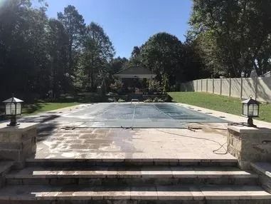 There is a large swimming pool in the backyard with a gazebo in the background.